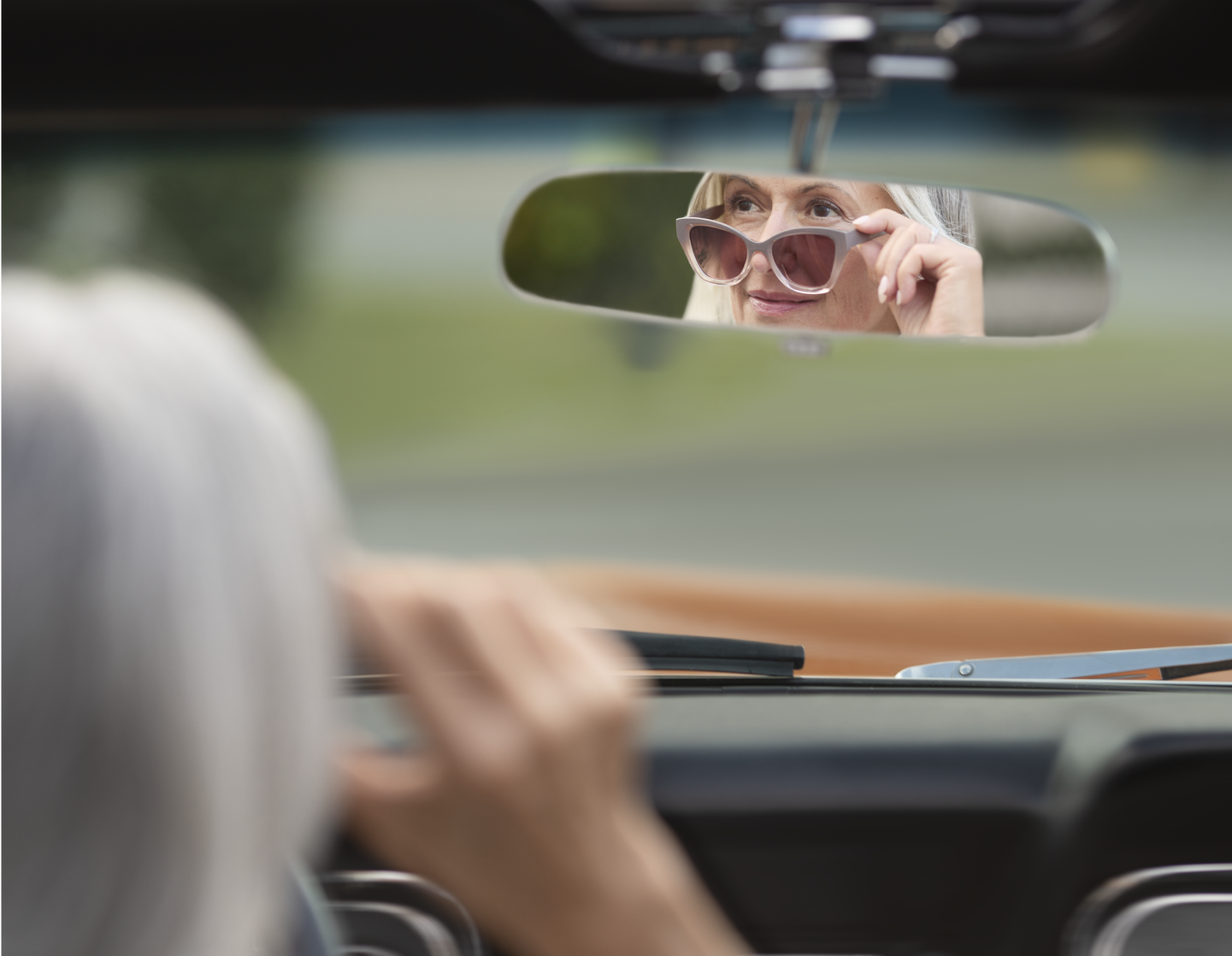 Woman looking into rearview mirror