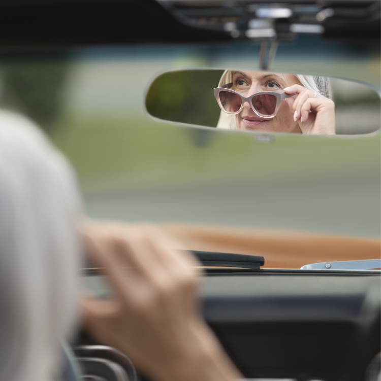 Woman looking into rearview mirror